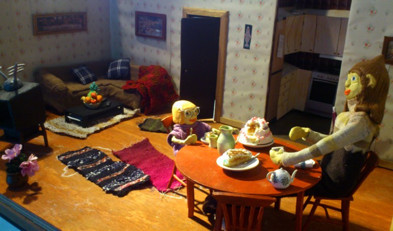 Så här hade vi ställt upp ett par kulisser inför semesterevalueringen. Gud och Anne festande på tårta vid matbordet. Tv soffa och dörr till Guds rum och kök i bakgrunden.